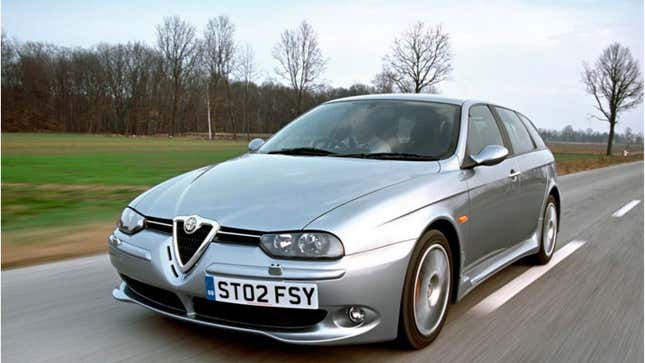 A photo of a silver Alfa Romeo 156 wagon driving on a highway. 