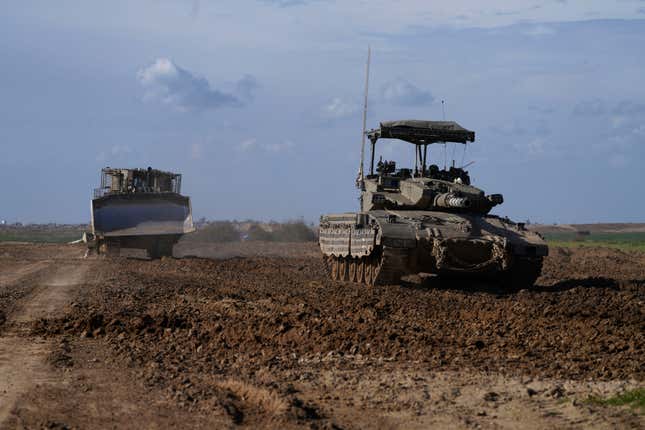 An Israeli tank and a military bulldozer return from the Gaza Strip, as they drive in southern Israel, near the Gaza border, Thursday, Feb. 1, 2024. (AP Photo/Tsafrir Abayov)