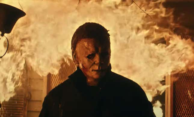 Michael Myers in Halloween Kills, walking away from a blazing house fire. 