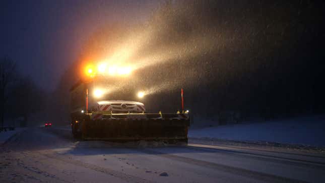 A snow plow clears a road 