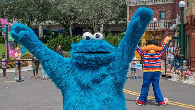 A man wearing a Cookie Monster costume at a theme park