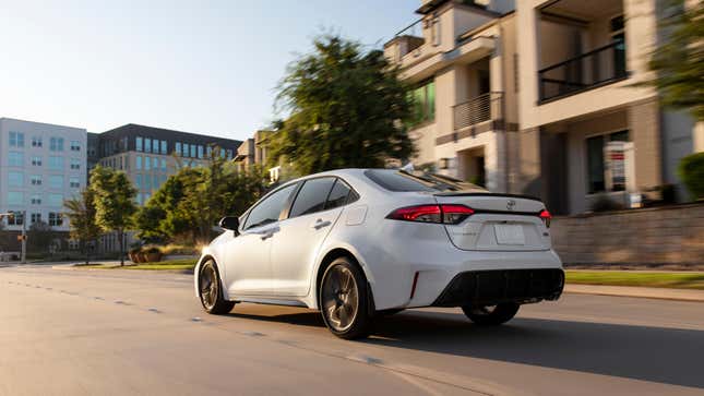 A white Toyota Corolla driving on a road