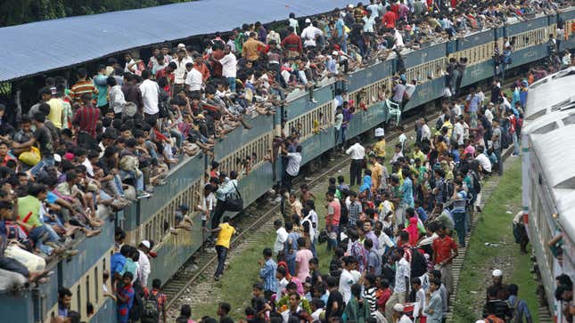 Passengers climb to board an overcrowded train at a railway station in Dhaka, Bangladesh.