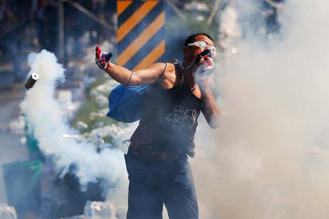 Others are using swimming googles to protect their eyes from the noxious fumes; this demonstrator hurled a tear gas canister back toward police.
