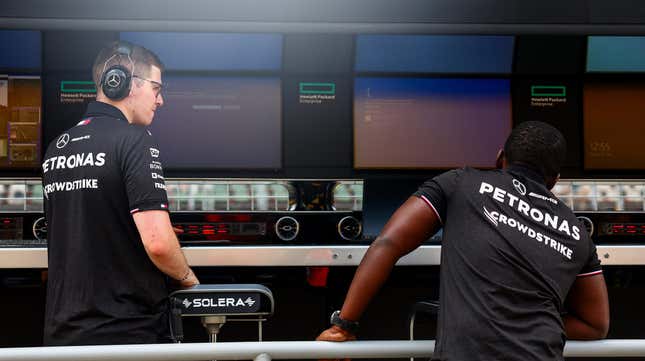 A Mercedes team member, whose shirt bears the logo of team sponsor Crowdstrike, looks on as Windows error screens are seen on their pitwall prior to practice ahead of the F1 Grand Prix of Hungary at Hungaroring on July 19, 2024 in Budapest, Hungary.