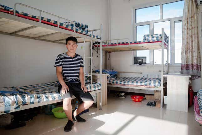 A local citizen of nearby Ordos, recent college graduate Hou Jie, 24, is a maintenance worker at the mine. He shares this dorm room with seven other employees.
