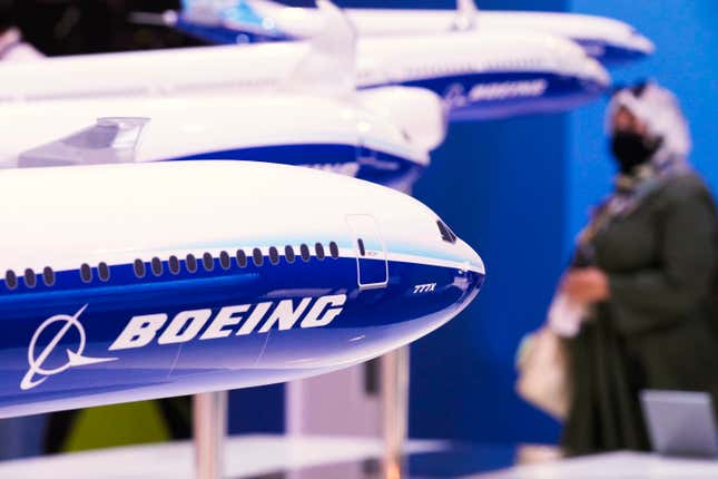 FILE - A woman walks by models of Boeing Co. aircraft, including the manufacturer&#39;s new Boeing 777X, at the Dubai Air Show in Dubai, United Arab Emirates, Wednesday, Nov. 17, 2021. Boeing reports their earnings on Wednesday, Jan. 31, 2024. (AP Photo/Jon Gambrell, File)