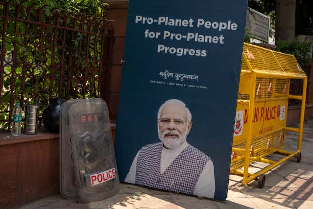 Police shields rest against a fence next to the poster of Indian Prime Minister Narendra Modi on a road leading to the venue for this week&#39;s summit of the Group of 20 nations in New Delhi, India, Thursday, Sept. 7, 2023. (AP Photo/Altaf Qadri)