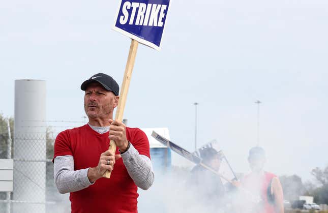 United Auto Workers union member Steve Bliss holds a picket sign during a strike along the south side of the Stellantis Toledo Assembly Complex on Friday, Oct. 13, 2023 in Toledo, Ohio. The United Auto Workers union expanded its strikes against Detroit automakers, ordering 7,000 more workers to walk off the job in Illinois and Michigan. The move announced Friday is supposed to put more pressure on the companies to improve their offers. (Phillip L. Kaplan/The Blade via AP)