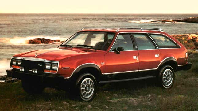 A photo of a red AMC station wagon parked near the sea. 