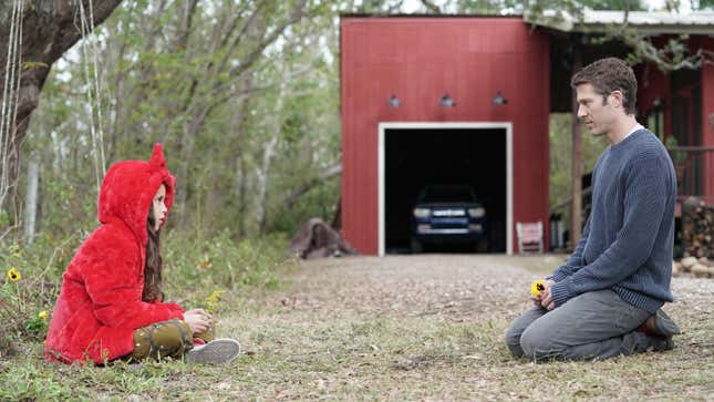 A small girl and a man sit facing each other