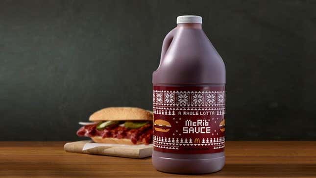 A jug of McRib sauce sits in front of a sandwich. 