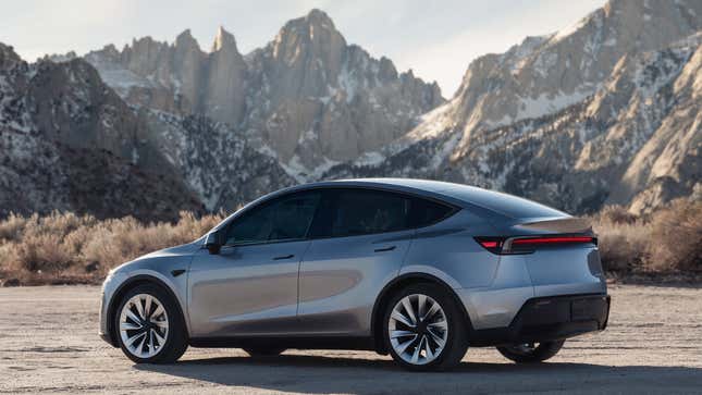 An image of a Tesla Model Y parked near some mountains. 