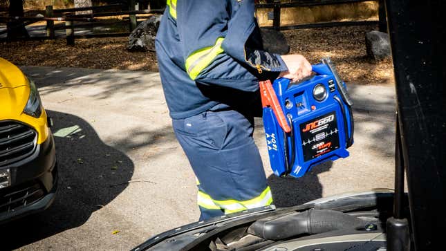 A photo of a person holding jumper cables 