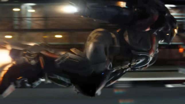 An Iron Man suit flies through a street