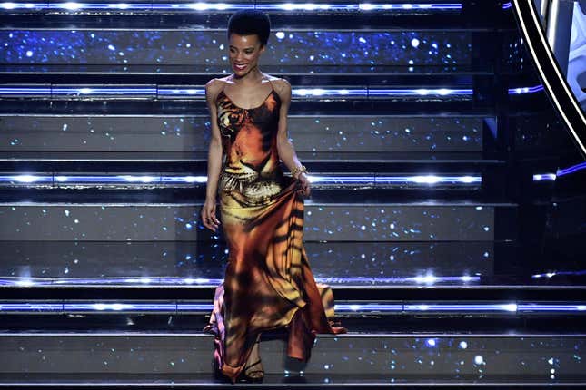 Lorena Monroe Cesarini appears on the stage of the Ariston theater on the occasion of the Sanremo songs Festival, in San Remo, Italy, Wednesday, Feb. 2, 2022. A Black Italian actress said she received on-line harassment after her appearance as a guest on Italy’s annual Sanremo music festival was announced. Lorena Monroe Cesarini told a live and TV audience on Wednesday that “evidently for someone, the color of my skin is a problem,” reading some messages she received on social media. They included messages saying she didn’t deserve being a guest at the music festival and that “they called you because you are black,” and one saying “maybe they called you to wash the staircase or put the flowers in vases.” 