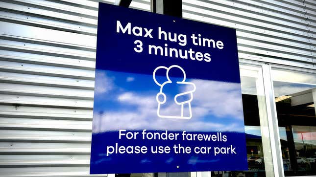 A blue sign informing passengers of the three-minute hug time limit at Dunedin Airport