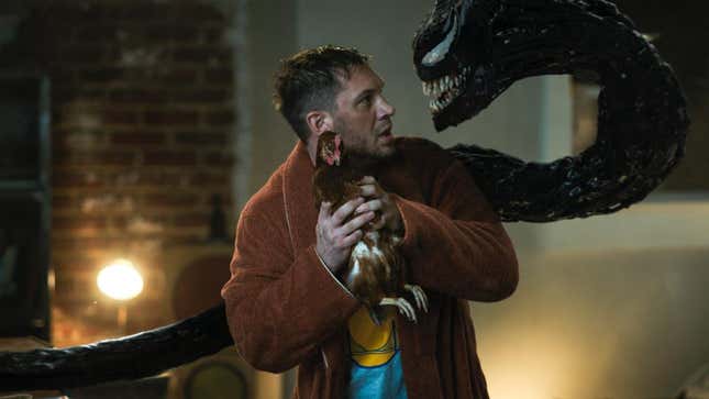 Tom Hardy staring at Venom the symbiote while holding a chicken. 