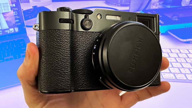 A Fujifilm X100VI camera with lens cap on against a blue background.