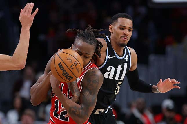ATLANTA, GEORGIA - FEBRUARY 12:  Trae Young #11 defends as Dejounte Murray #5 of the Atlanta Hawks knocks the ball away from Ayo Dosunmu #12 of the Chicago Bulls during the fourth quarter at State Farm Arena on February 12, 2024 in Atlanta, Georgia.  NOTE TO USER: User expressly acknowledges and agrees that, by downloading and/or using this photograph, user is consenting to the terms and conditions of the Getty Images License Agreement.  (Photo by Kevin C. Cox/Getty Images)