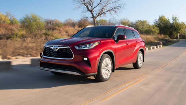 A red Toyota Highlander Hybrid on a two-lane road