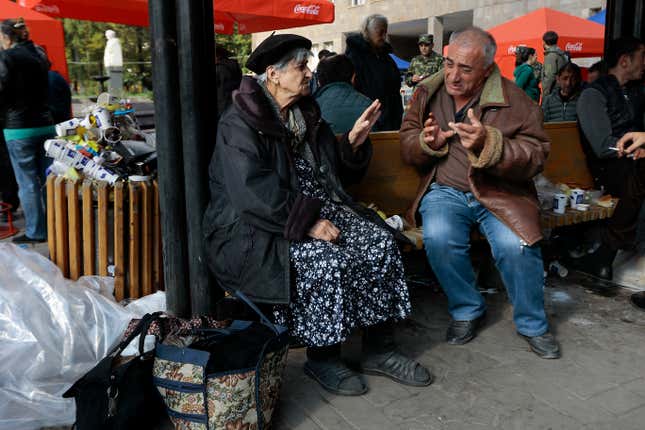 Ethnic Armenian man and woman from Nagorno-Karabakh talk to each other sitting near a tent camp after arriving to Armenia&#39;s Goris in Syunik region, Armenia, on Saturday, Sept. 30, 2023. Armenian officials say that by Friday evening over 97,700 people had left Nagorno-Karabakh. The region&#39;s population was around 120,000 before the exodus began. (AP Photo/Vasily Krestyaninov)