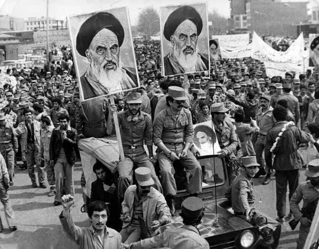 The Iranian Islamic Republic Army demonstrates in solidarity with people in the street during the Iranian revolution. They are carrying posters of the Ayatollah Khomeini, the Iranian religious and political leader. 