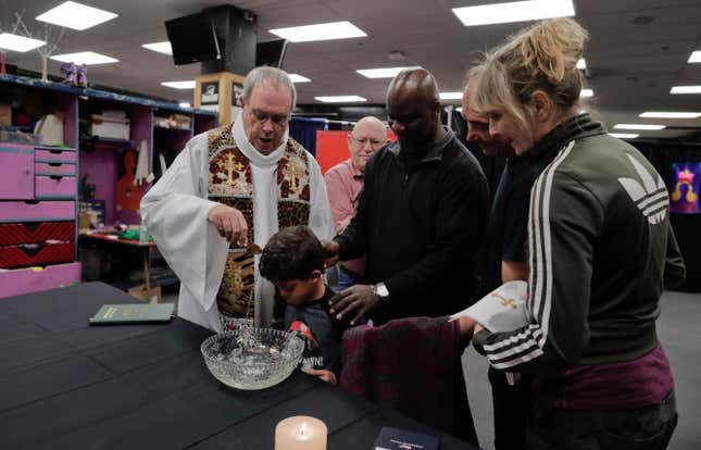 Rev. Jerry Hogan, left, of the U.S. Conference of Catholic Bishops’ Circus and Traveling Shows Ministry, leads a baptism service for 6-year-old Eddie Strickland, the son of Jimmie Strickland, a crew member, May 4.