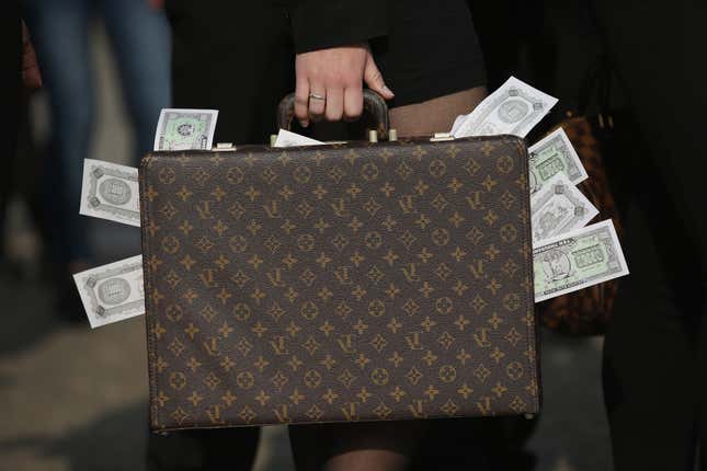 Un activiste tenant une valise remplie de faux billets.