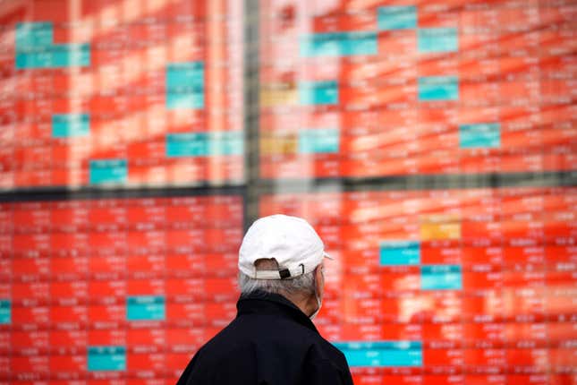 FILE - A person walks in front of an electronic stock board showing Japan&#39;s Nikkei 225 index at a securities firm in Tokyo, Jan. 22, 2024. Asian markets were mostly higher Wednesday, March 20, 2024 ahead of expected guidance by the Federal Reserve on the timing of its cuts to interest rates. (AP Photo/Eugene Hoshiko, File)