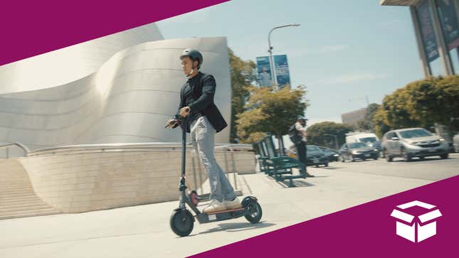 A man riding down the sidewalk on an electric scooter.