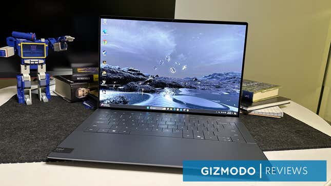A Dell XPS 14 next to a few books and toys with the logo for Gizmodo reviews in bottom right.