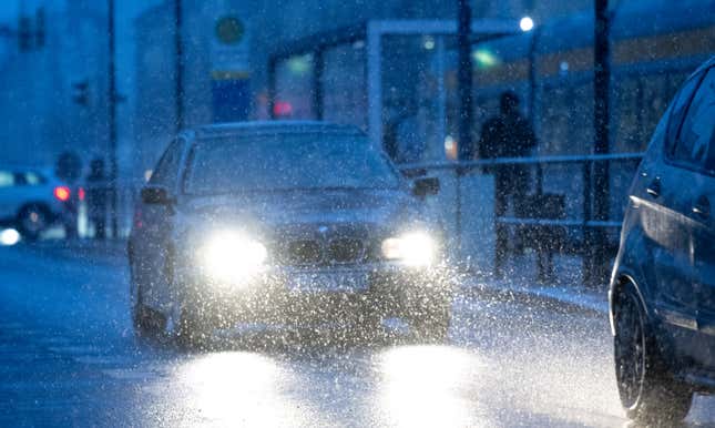 17. Januar 2024, Sachsen, Leipzig: Schneeflocken fallen in die Scheinwerfer von Autos in Leipzig. Am selben Tag warnte der Deutsche Wetterdienst vor extremer Eisglätte und starkem Schneefall in Teilen Deutschlands.