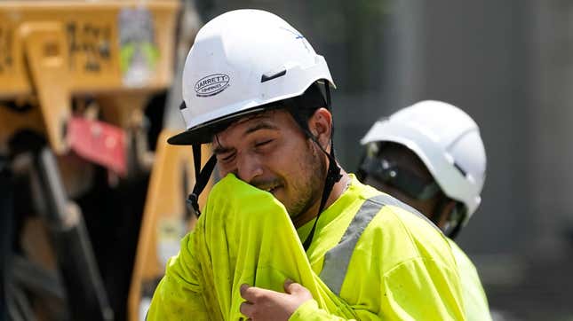 Construction worker Fernando Padilla wipes his face as he works in the heat, Friday, June 30, 2023, in Nashville, Tennessee.