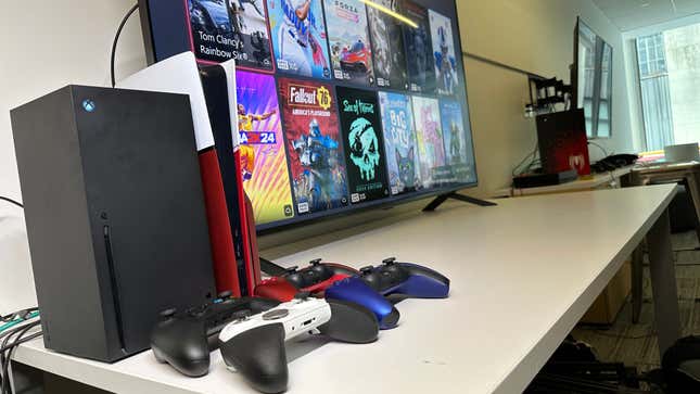 An Xbox Series X and PlayStation 5 console surrounded by controllers and a TV showing what games are currently available for streaming.