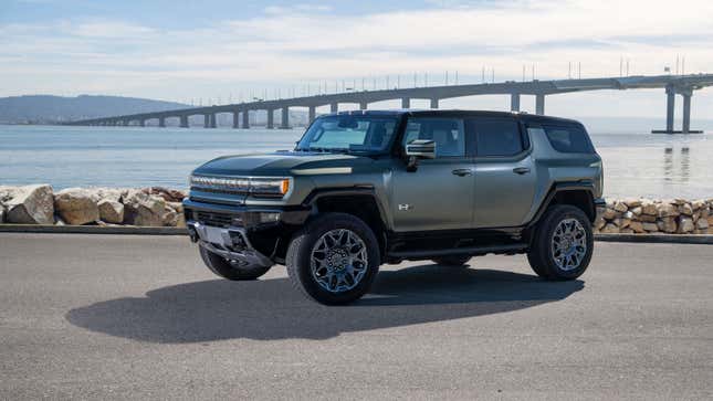 A photo of a dark green Hummer EV SUV. 