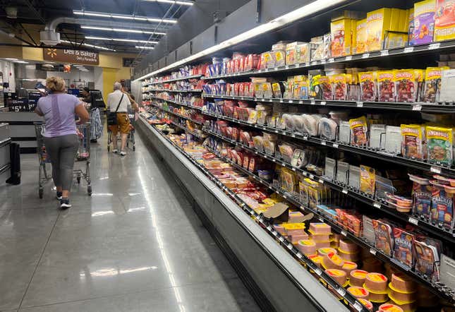 Customers shop in the deli meat aisle of a grocery store on October 17, 2024 in Miami, Florida.