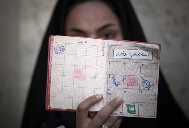 A woman holds her identification in front of her face as she rests after voting at a polling station during Iran’s parliamentary election in southern Tehran March 2, 2012.