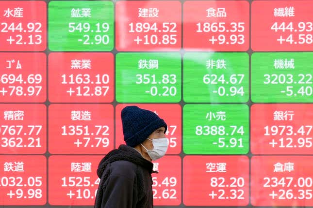 FILE - A person walks in front of an electronic stock board showing Japan&#39;s sector Indices at a securities firm in Tokyo, March 22, 2024. Asia stocks were mostly higher on Tuesday, April 9, 2024, with investors mainly focusing on a U.S. inflation report and what it means for interest rate cuts by the Federal Reserve.(AP Photo/Eugene Hoshiko, File)