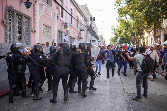 Police try to keep back supporters of Guatemalan President-elect Bernardo Arévalo who are protesting a delay in the start of the legislative session to swear-in new lawmakers on Arévalo&#39;s inauguration Day, outside Congress in Guatemala City, Sunday, Jan. 14, 2024. (AP Photo/Santiago Billy)