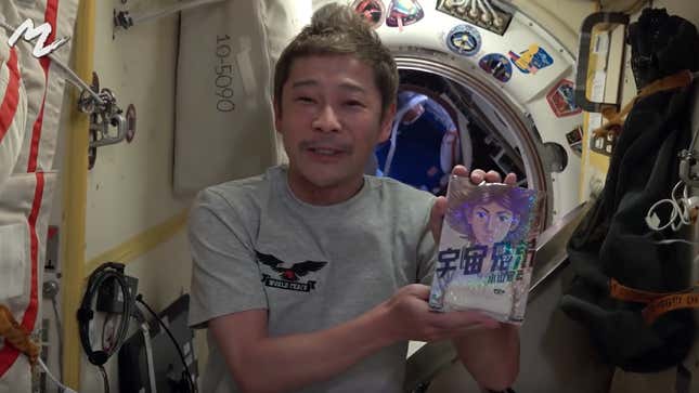 Maezawa holds up his copy of the Space Brothers manga. 