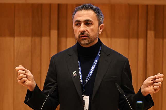 Mustafa Suleyman holds two fists up while speaking