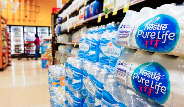 A woman walks past an aisle with bottled water at a supermarket in Los Angeles, California on March 15, 2018.