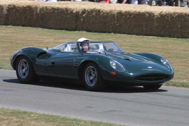 A photo of Gran Turismo creator Kazunori Yamauchi driving the only Jaguar XJ13 ever built at Goodwood.