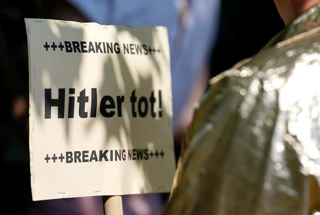 An anti-fascism sign reads: Breaking news—Hitler is dead!”