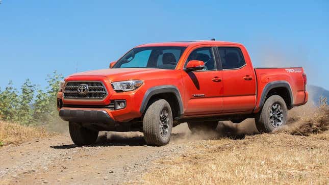 Ein leuchtend orangefarbener Toyota Tacoma TRD Off-Road, der im Dreck rutscht