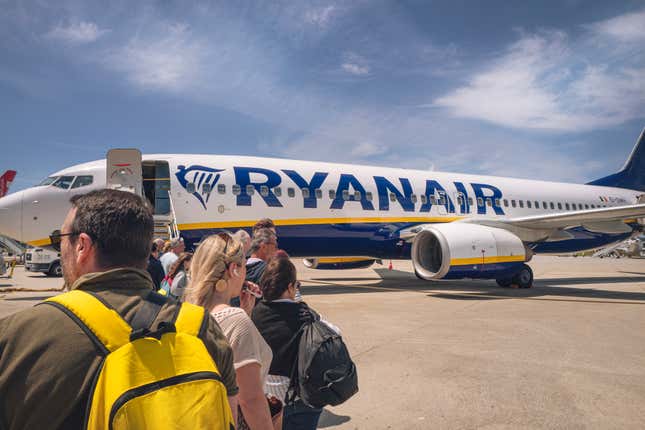 Des gens attendent de monter à bord d’un avion Ryanair. 