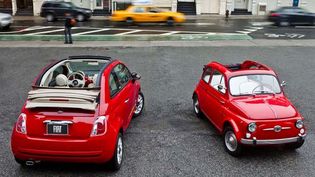 A photo of a new, red Fiat 500 parked next to an original, red Fiat 500. 