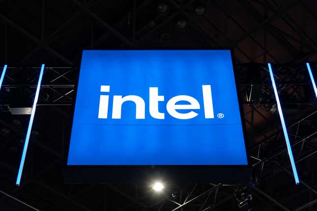 blue illuminated intel logo on display against a black ceiling