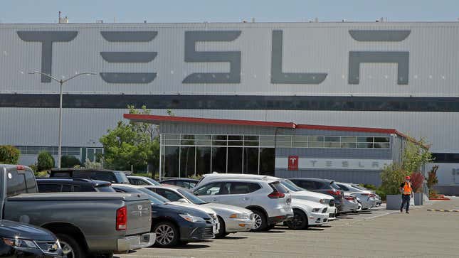 FILE - A man walks in the Tesla plant parking lot, May 11, 2020, in Fremont, Calif. Factory workers at Tesla have been told to expect pay raises in 2024, a move that comes as the United Auto Workers union tries to organize the electric vehicle maker&#39;s U.S. plants. The UAW said Thursday, Jan. 11, 2024, that Tesla workers have told the union about company statements on the raises, which did not give details about the size of the increases. (AP Photo/Ben Margot, File)